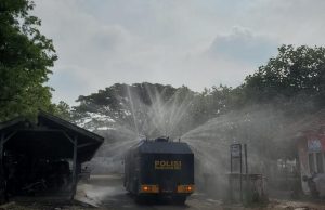 Gunakan Watercanon,Polres Blitar Kota Semprotkan Disinfektan di Pasar Dimoro